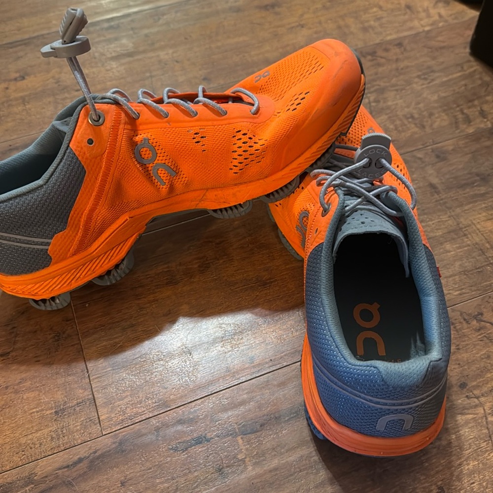 Neon orange on clouds running shoes used